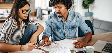 A woman and man reviewing their financial papers